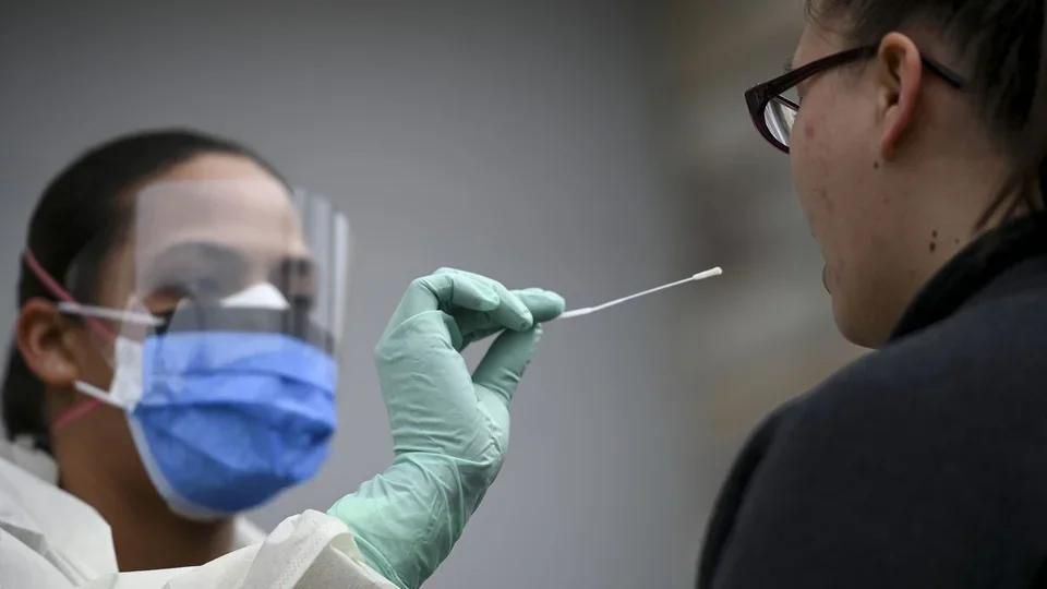 picture of a healthcare worker taking samples with a swab for a covid-19 test