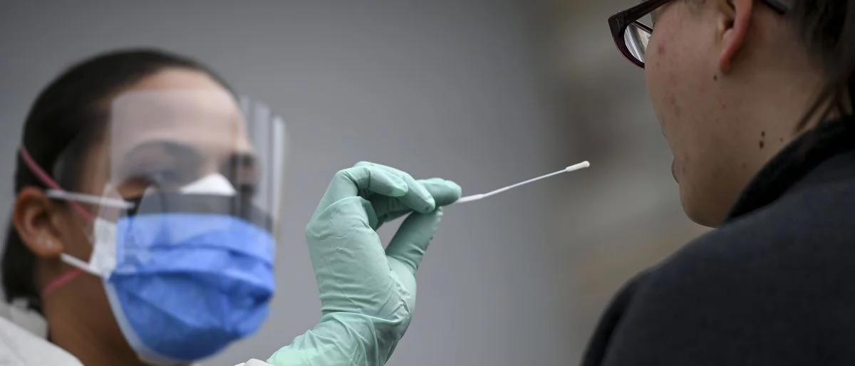 picture of a healthcare worker taking samples with a swab for a covid-19 test