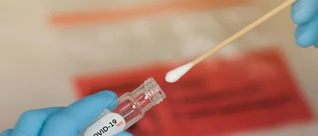 picture of a test tube and a swab for a covid-19 test
